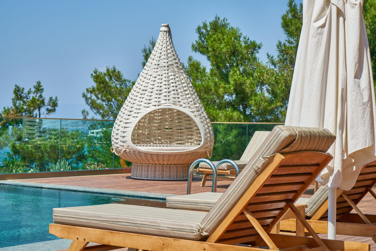 Teak wood sun loungers beside a resort pool