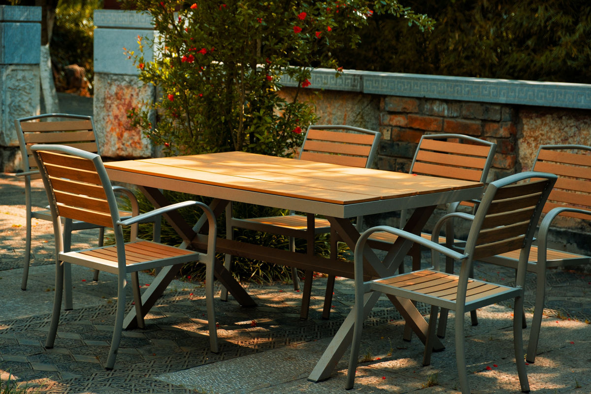 Outdoor wooden patio table and chairs in a sunny garden setting